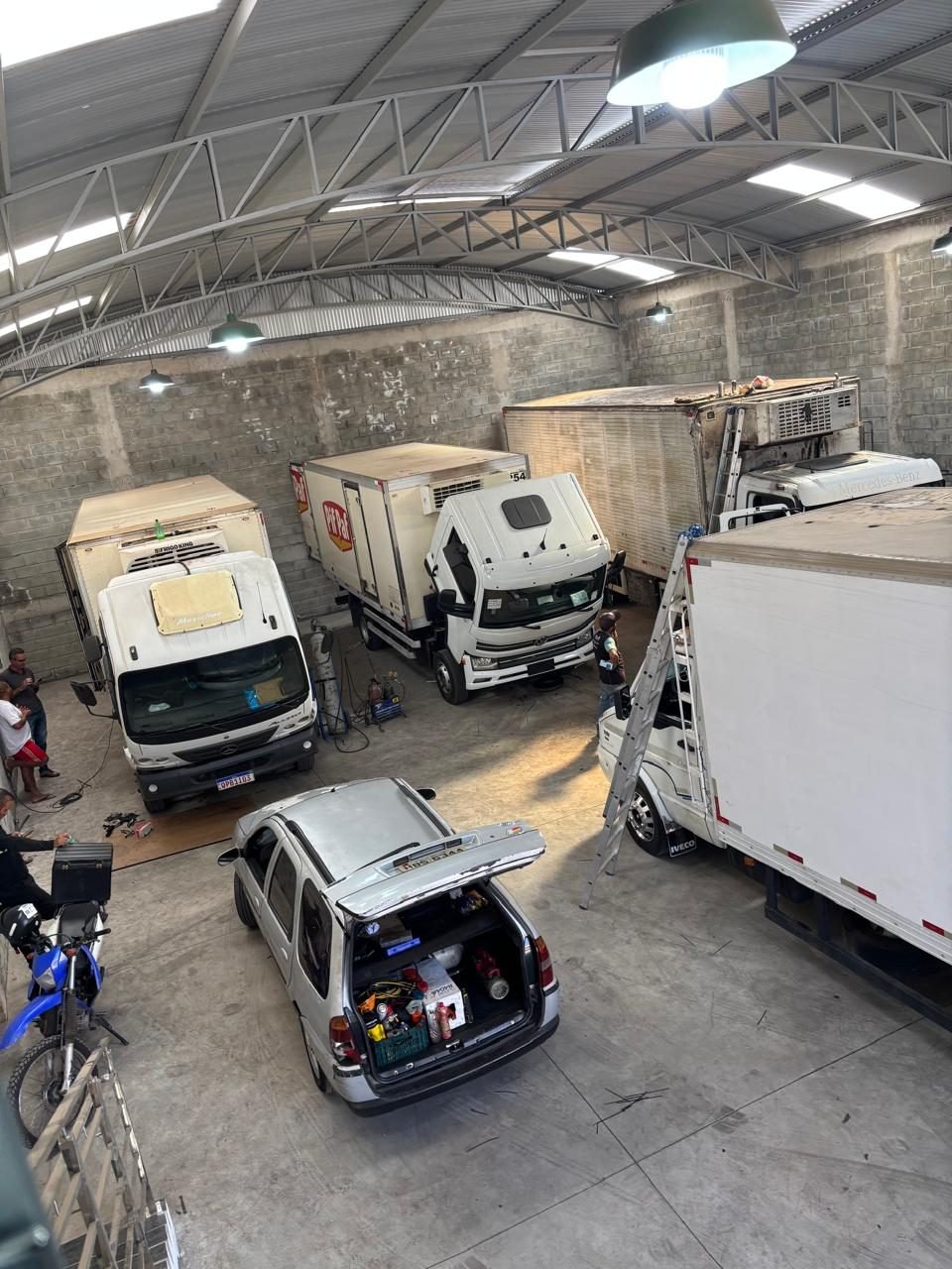 Frota de veículos refrigerados em manutenção no galpão da ThermoLider BH